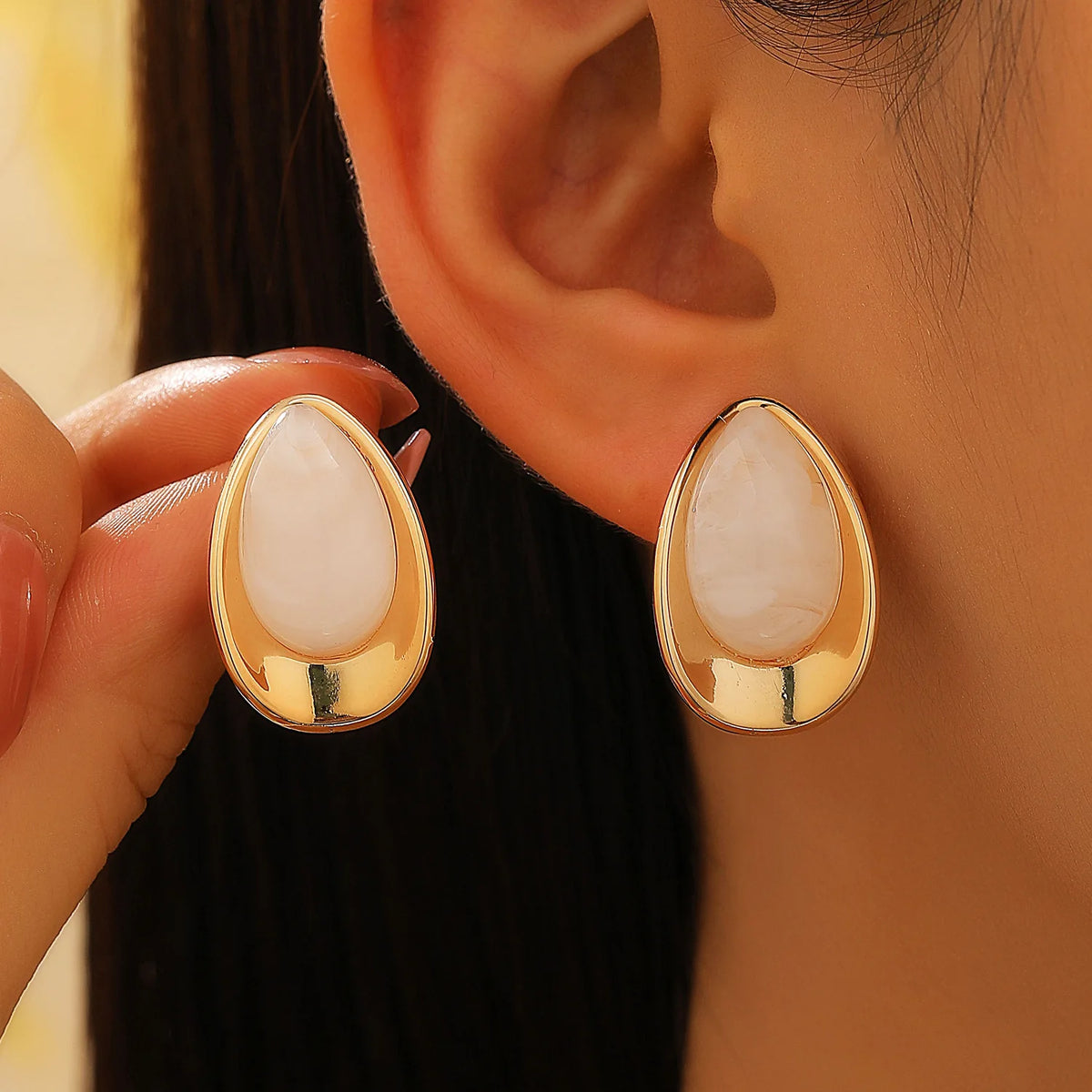 Earrings with a white teardrop silhouette