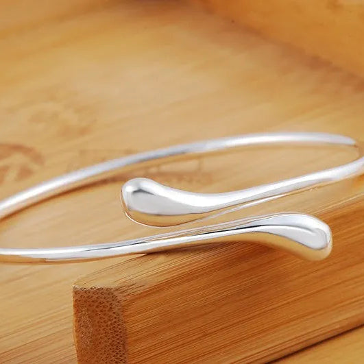 Open bracelet with flowing double teardrop