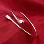 Open bracelet with flowing double teardrop
