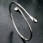 Open bracelet with flowing double teardrop