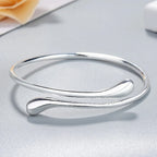 Open bracelet with flowing double teardrop