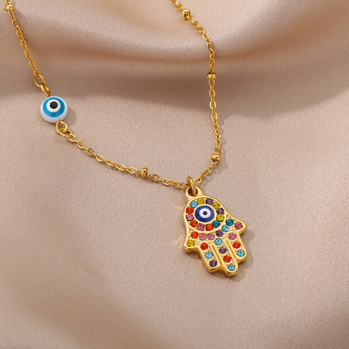 Necklace with multicolored Arabic evil eye protection pendant and Fatma's hand in gold